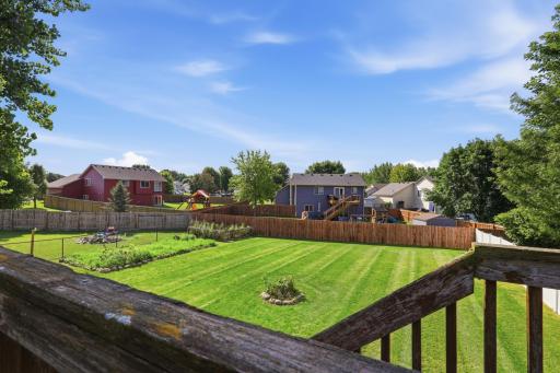 Taken from the deck, this view highlights the depth of the fenced backyard and its easy connection to neighboring green space. It's a peaceful spot to enjoy morning coffee or watch the sunset over the yard.