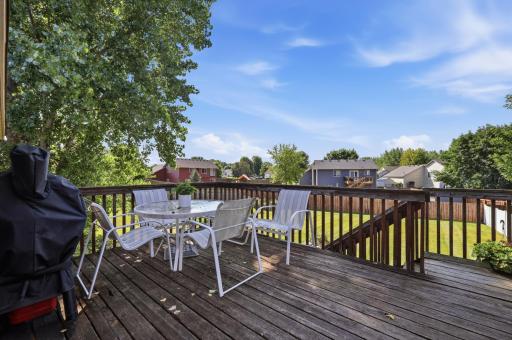 The upper deck offers a private spot for outdoor dining, complete with sweeping views over the fenced backyard and neighborhood tree line. Mature shade trees keep this space comfortable throughout the summer.