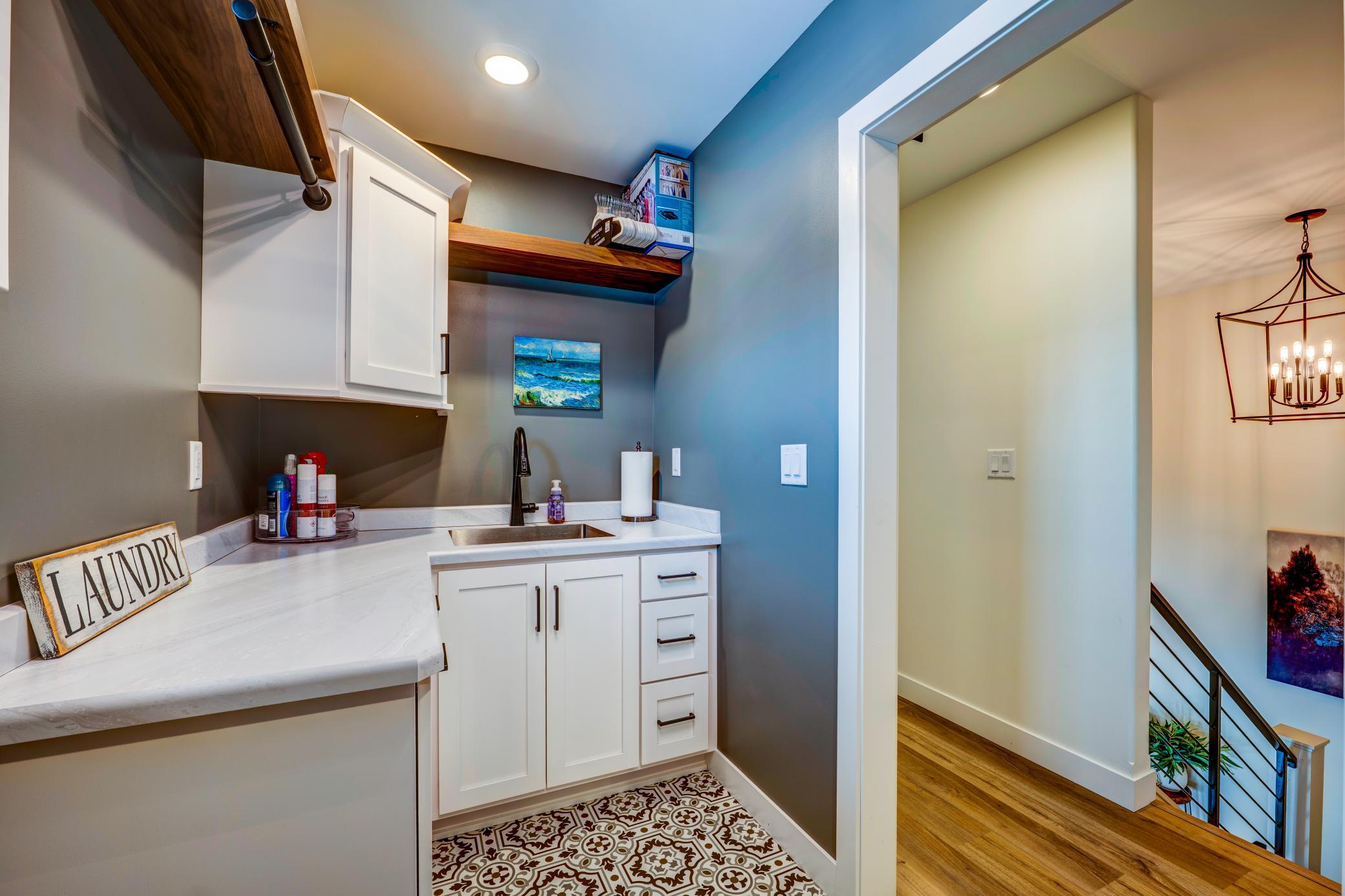 Laundry with additional storage and sink.