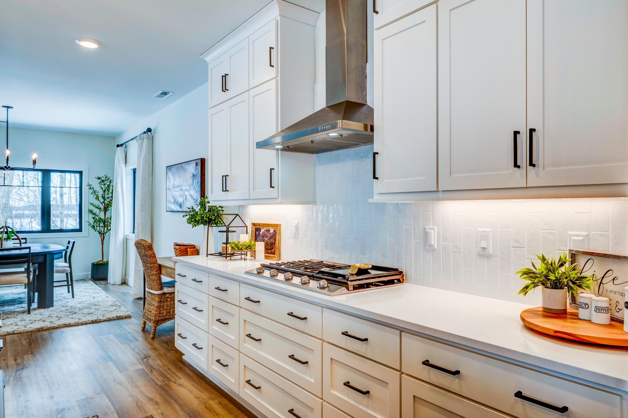 Gas cooktop with bonus side griddle, makes preparing meals easier! Cambria countertops and tiled backsplash tie the kitchen finishes together.