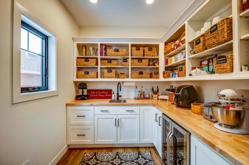 A Butler's pantry- complete with a sink, lots of storage and a wine cooler is the chef's kiss