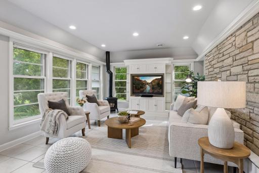 Cozy up by the fire surrounded by floor-to-ceiling windows and dramatic accent limestone walls - your front-row seat to your peaceful backyard views.