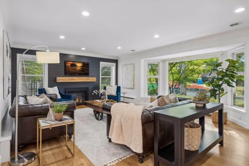 Sun-drenched living space anchored by a sleek gas fireplace, classic bay window, and newly refined trim and lighting.