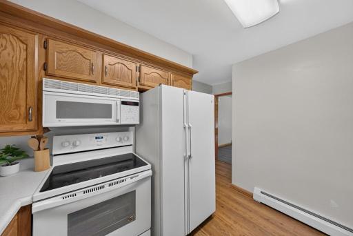 Main level kitchen. Behind the kitchen wall is the 1/2 bath and the door to the garage. To the right of the frig is the door to the lower level and doorway into the front room.