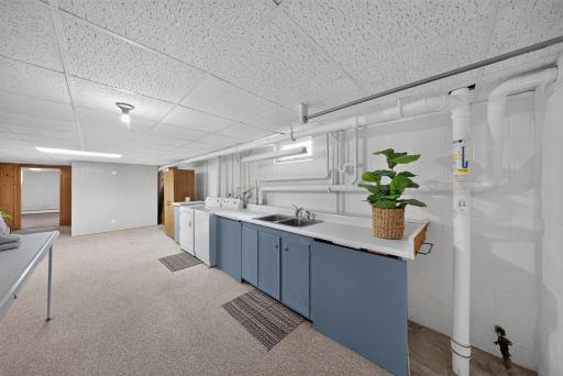 Laundry room in the lower level -there is a large work area, for folding, sorting and keeping the baskets etc as well as a sink for soaking and prewashing items.