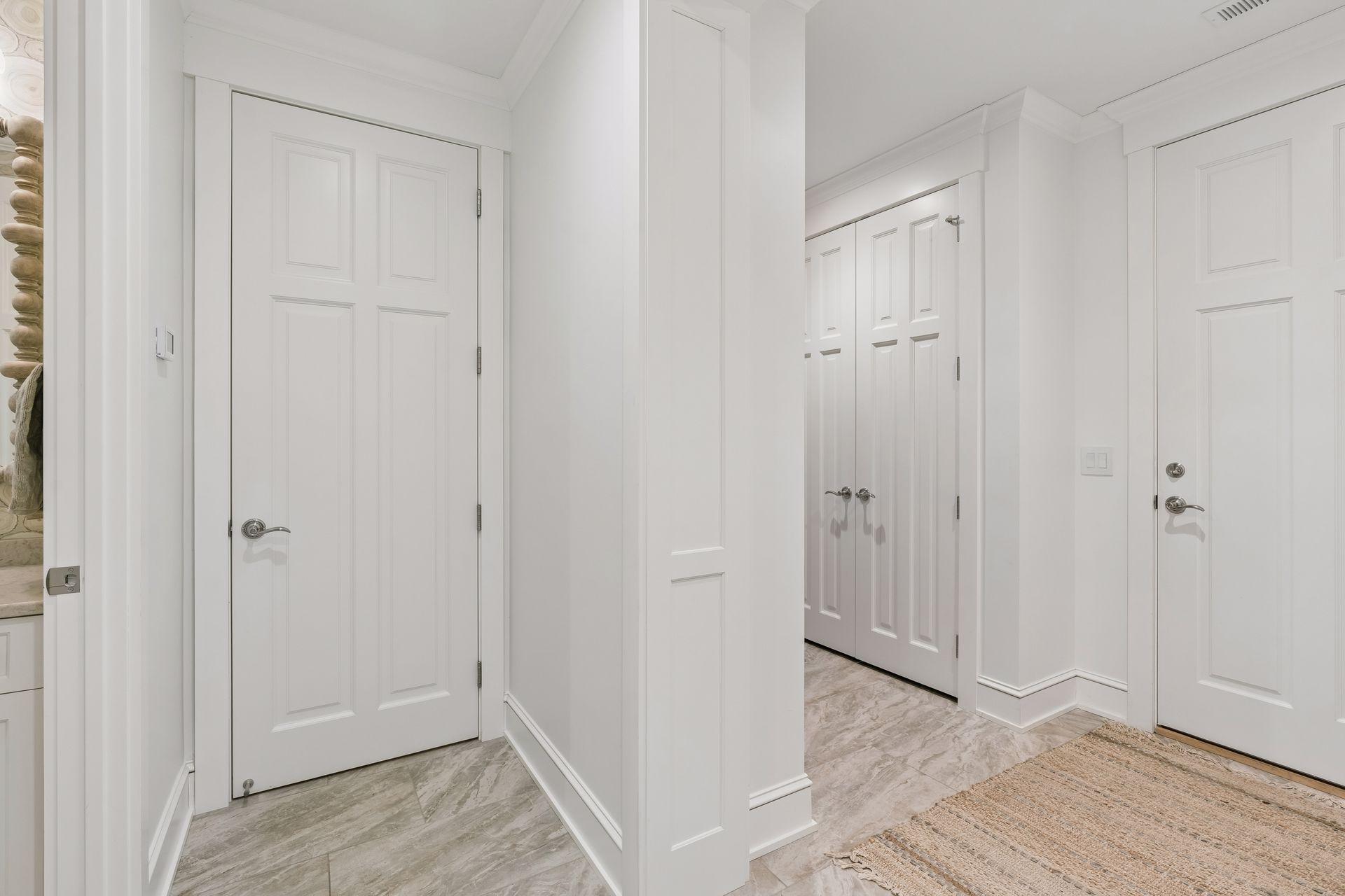 service entry from garage, with closet and bench area as well as large storage room and elevator access