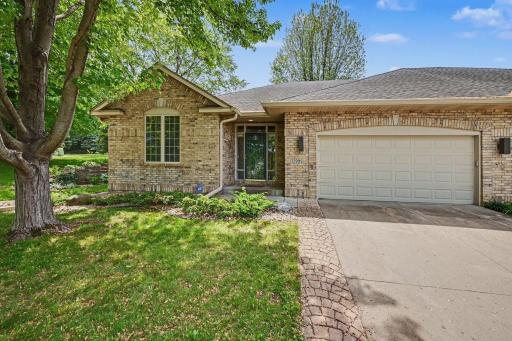 Brick-front rambler townhome in Apple Valley's Summit community with a 2-car garage and mature landscaping.