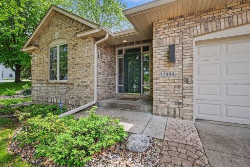 Welcoming front entry with brick exterior and association-maintained townhome living.