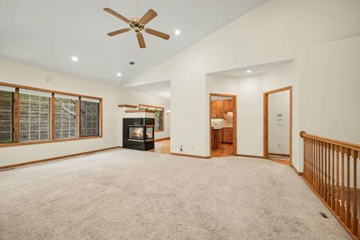 Spacious living room with vaulted ceilings, recessed lighting, and fireplace.