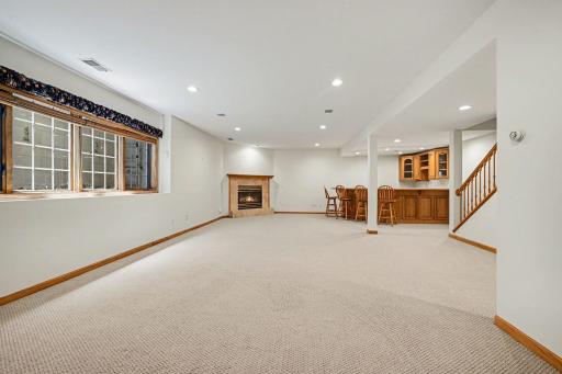 Finished lookout lower level family room with fireplace, wet bar, and room to relax.