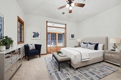 Main-level primary bedroom with private bath access and nearby sunroom. (virtually staged to show potential)