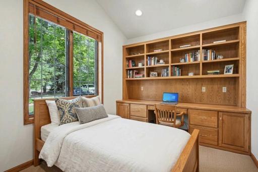 Main-level den/flex room with custom built-ins, virtually staged to show guest-space potential.