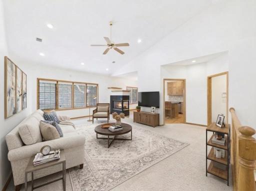 Vaulted living room with fireplace and large windows, staged to help buyers understand the scale.