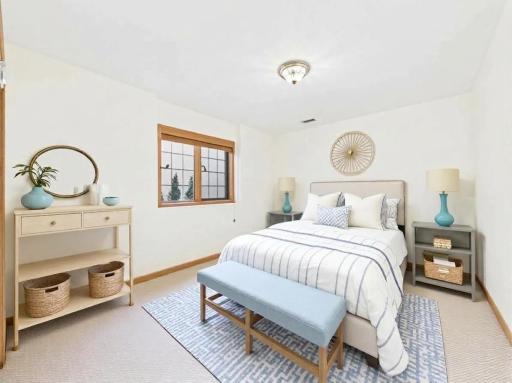Lower-level bedroom, virtually staged to show guest-room furniture placement and room scale.