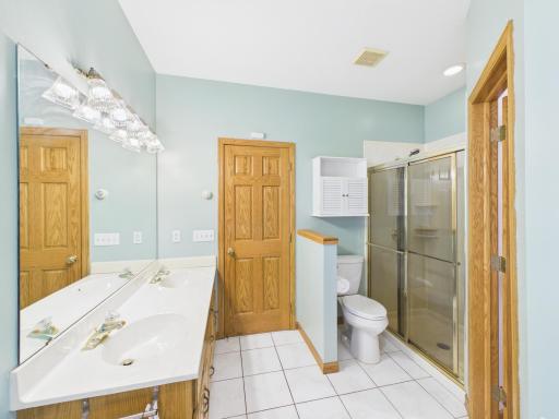 Primary bath with dual sinks, soaking tub, separate shower, and walk-in closet access.