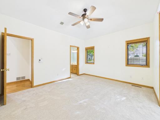 Primary bedroom with main-level convenience, natural light, and private bath access. Sunroom located