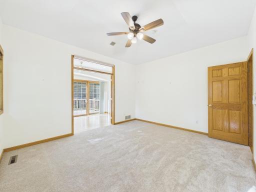 Main-level primary bedroom with convenient connection toward the sunroom and private bath.