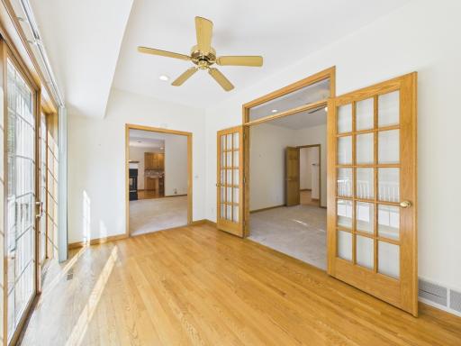 South-facing sunroom connecting the living room and primary bedroom with views toward the deck.