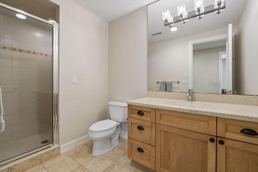 The lower level bathroom boasts custom tilework and fresh paint.