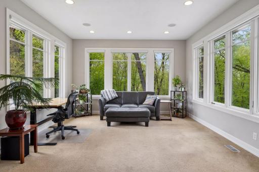 The sunroom is surrounded by green views on all sides. You'll want to spend all your time in this 4-season space!
