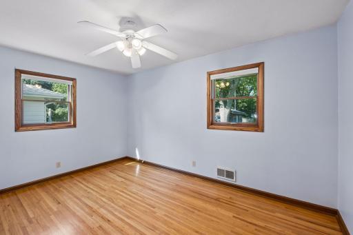 Three bedrooms on the main floor, all with hardwood floors and ceiling fans