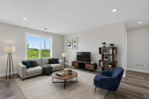The living room features durable LVP flooring and modern recessed lighting. Photo has been virtually staged.