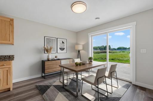 The dining area features a patio door that leads out to the backyard patio. Photo has been virtually staged.