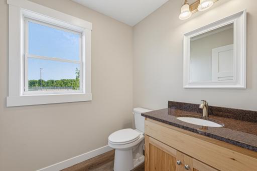 The half bathroom features a granite topped vanity.