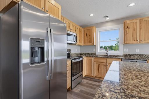 The kitchen features a full suite of S.S. appliances, including an electric range, dishwasher, microwave, and refrigerator.