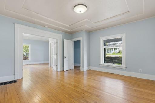 Large main floor living room with real hardwood flooring. French doors lead to another bedroom, or use it as a 2nd family room, office space or playroom.