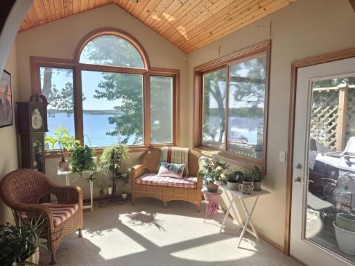 Enjoy the sun and the views from the sunroom, with easy access to the deck that wraps around the lake side of the home.