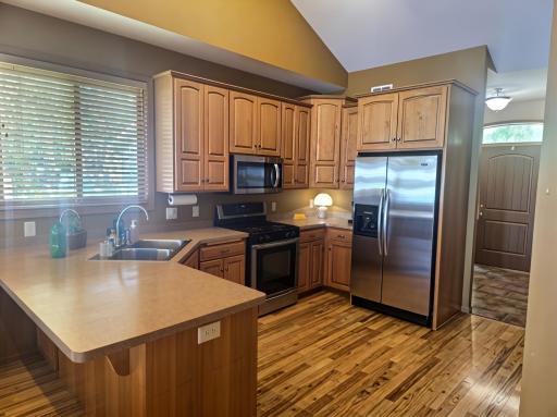 Large custom cabinets with stainless steel appliances welcome you into the open concept kitchen.