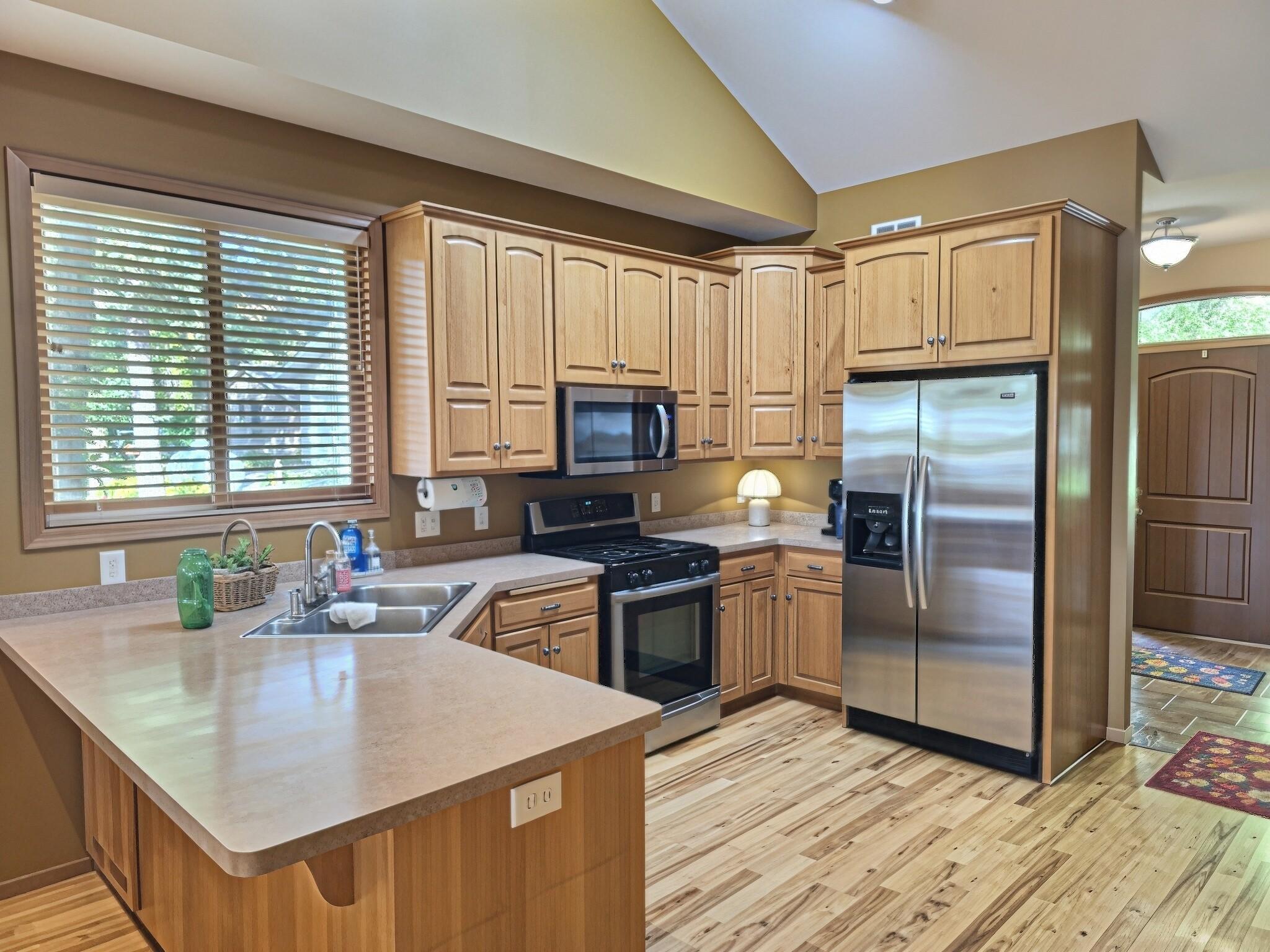 Large custom cabinets with stainless steel appliances welcome you into the open concept kitchen.