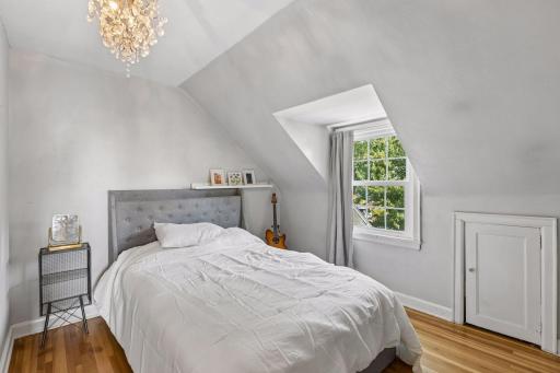 Upper level 3rd bedroom with hardwood floors looks out to front yard.