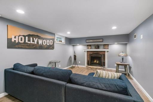 Lower level family room with laminate flooring and wood burning fireplace.