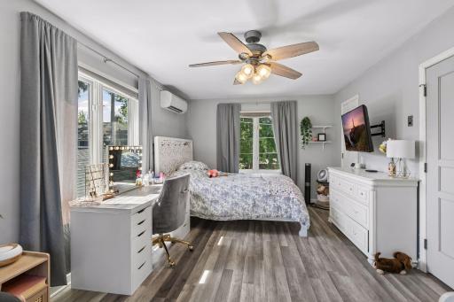 Upper level main bedroom is bright and sunny with laminate flooring.