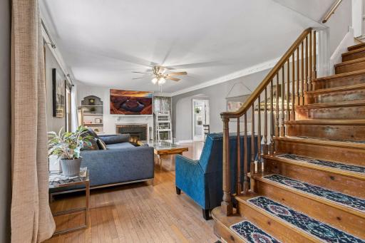 Spacious living room with woodburning fireplace and hardwood floors.