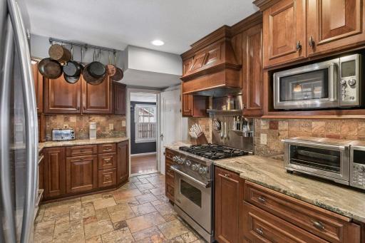 The updated kitchen features high-end finishes, granite countertops, soft close drawers and premium appliances, blending timeless character with modern convenience.