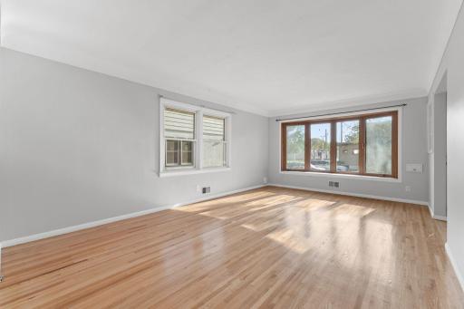 Bright living room angle that highlights the hardwood floors and natural light.