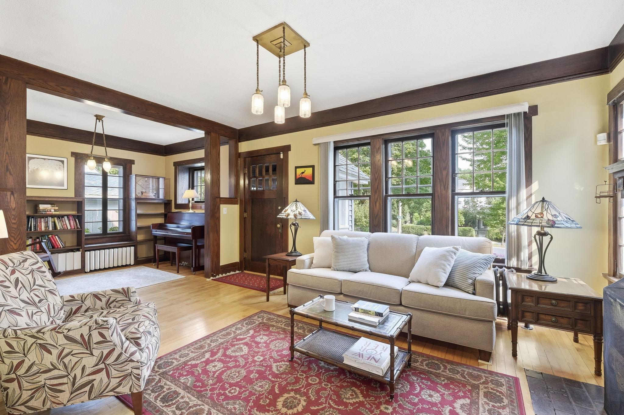The large living room windows shed wonderful natural light on the hardwoods! note the sitting room!