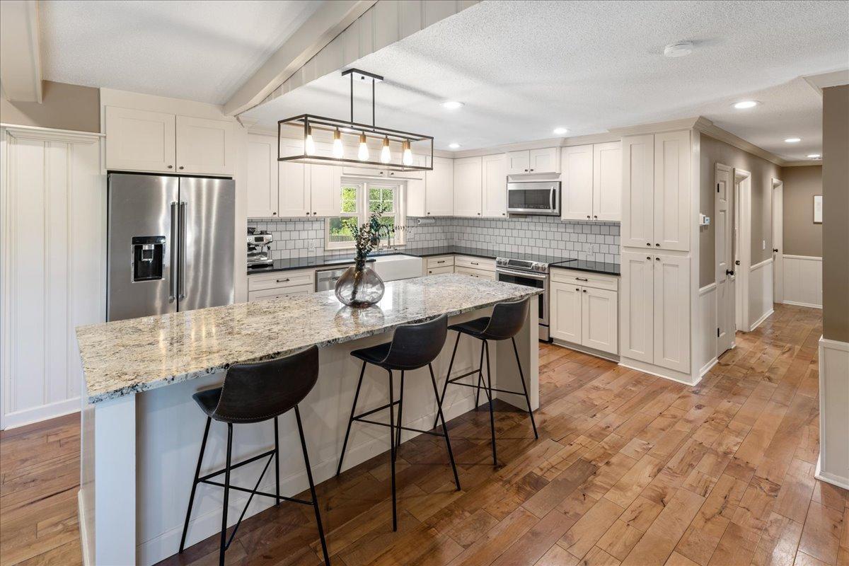 Gorgeous kitchen features a massive center island, granite countertops, tiled backsplash, walk-in pantry and stainless steel appliances.