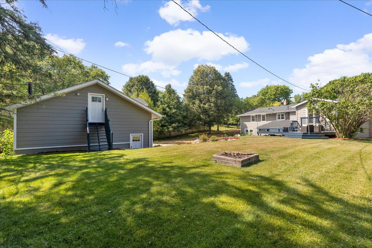 Spacious 1/2 acre lot features mature trees and firepit for that "Up North" feel!