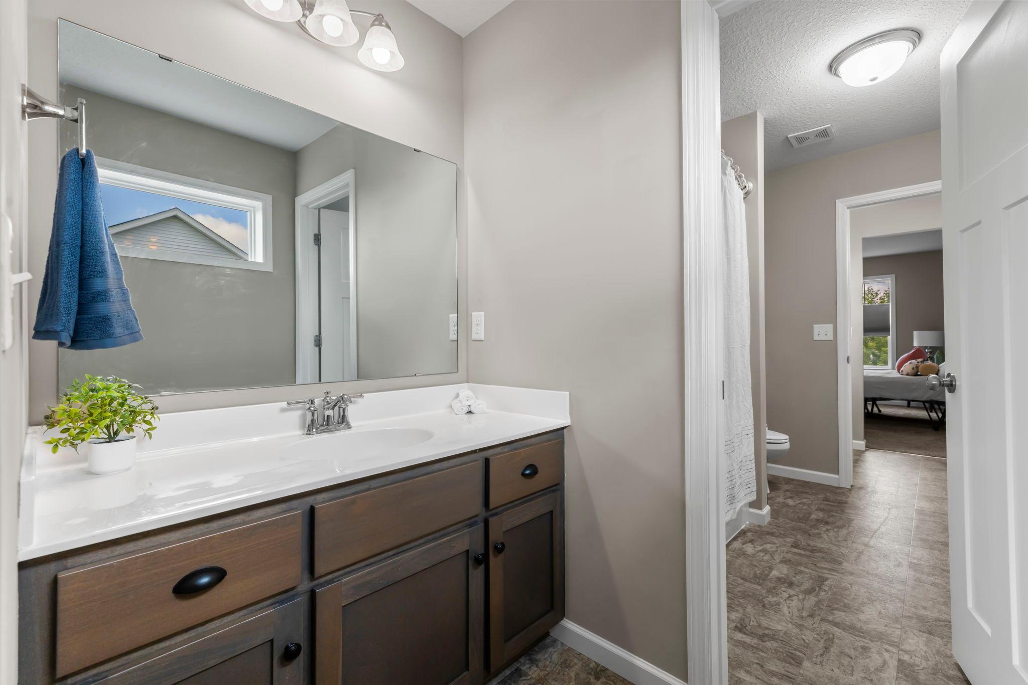 Upper level Jack & Jill Bath with vanities on each side with toilets featuring bidets