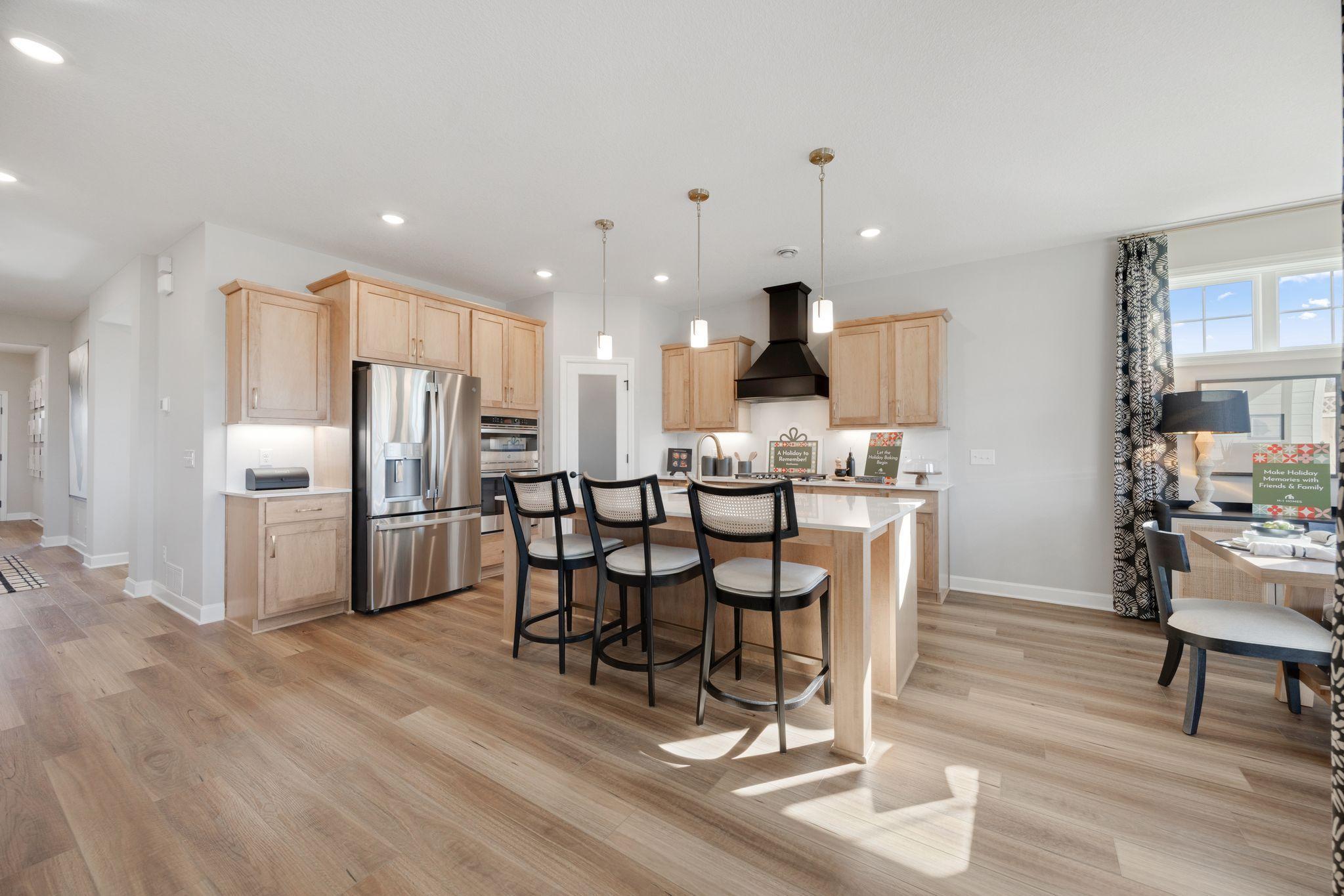 Open concept kitchen, dining and living area make the home feel bright and airy. Perfect for entertaining. Photo of model home, options and finishes may vary.