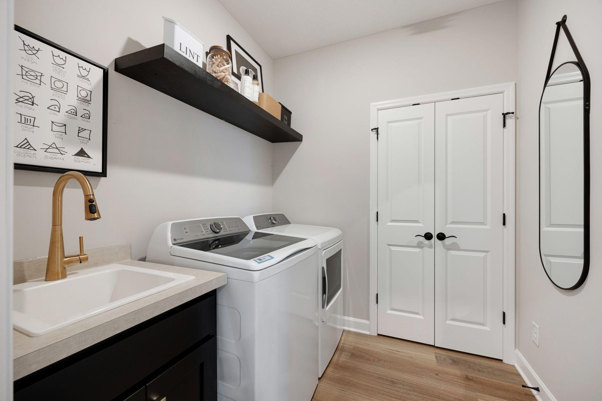 Laundry room with closet and laundry sink! Washer and dryer are included with the home.