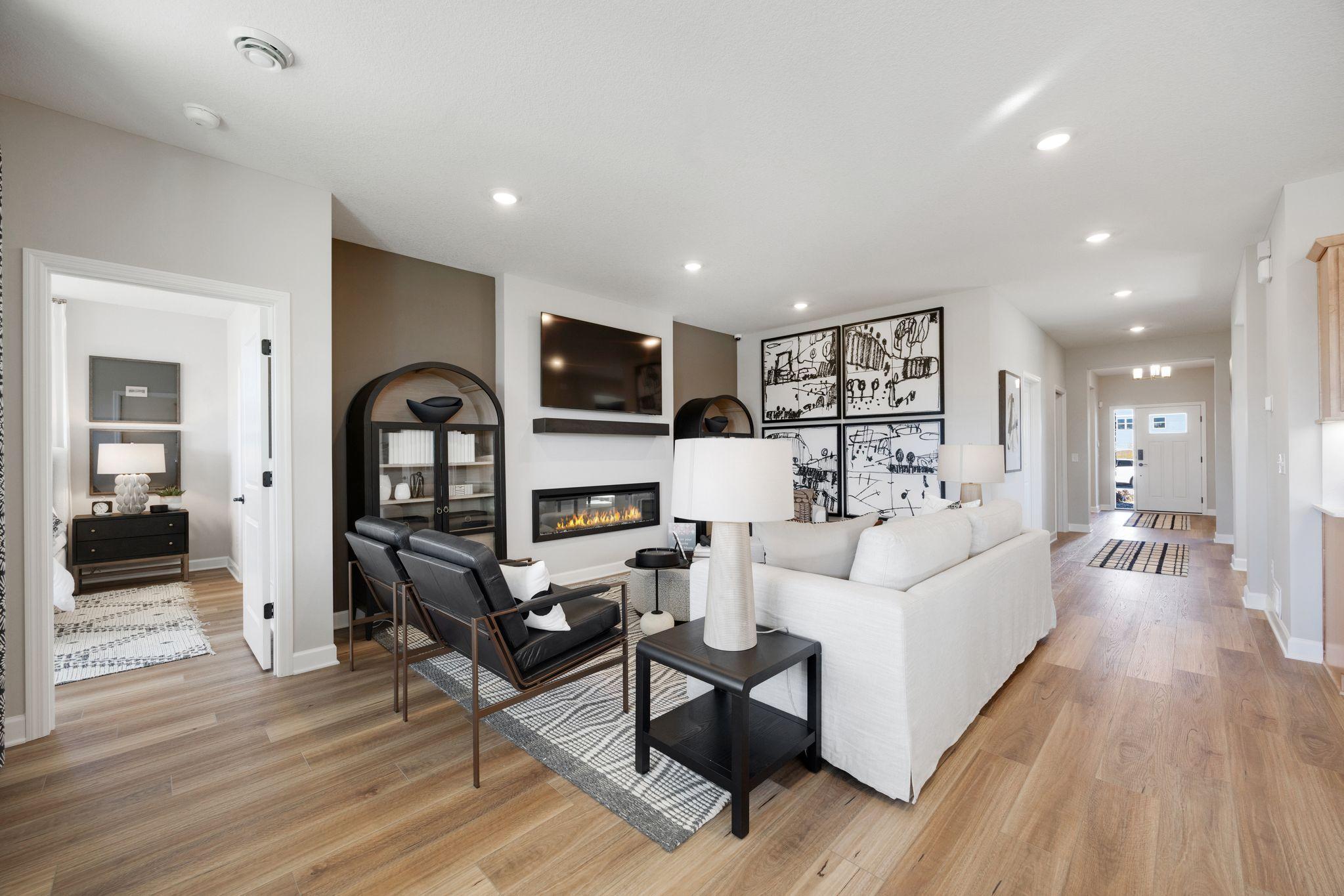 Family room is centered around an electric fireplace, with outlet above to seamlessly hang a TV.