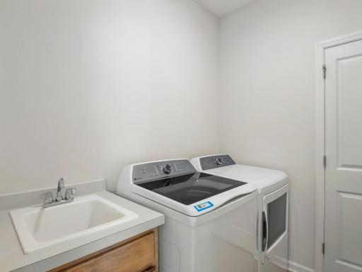 Laundry room with closet and laundry sink! Washer and dryer are included with the home.