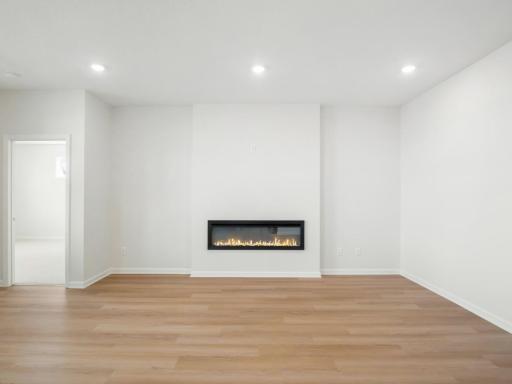 Family room is centered around an electric fireplace, with outlet above to seamlessly hang a TV.