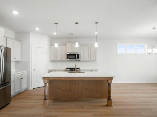 The heart of the home! Large island with quartz countertops and stainless steel GE appliances, all included with the home.