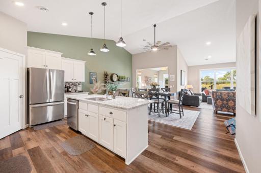 Kitchen and living room with LVP flooring and vaulted ceilings